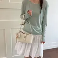 Elegante borsa sottobraccio bianco crema con ciondolo a forma di orsetto per lo stile - Bianco avorio