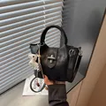 Chic black bucket handbag with niche design, silver twist lock and white puppy charm - Black (With Pendant)