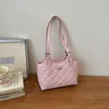 Vista dettagliata dell'elegante motivo trapuntato rosa e del logo metallico su questa borsa - Rosa