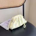 Stylish light yellow cloud bag featuring pastel blue polka dots and thin shoulder straps - Yellow