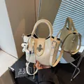 Elegant cream leather bucket bag for women with top handles and adjustable crossbody strap - Off-white (With Pendant)