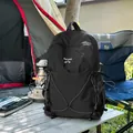 Sac à dos de camping noir robuste avec logo montagne sur une table de camping. - Noir