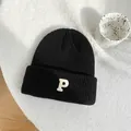 Detailed macro view of black knitted beanie texture with white embroidered letter P - 55-59cm (Elastic) / Black