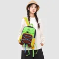 Detailansicht eines farbenfrohen Outdoor-Wanderrucksacks an einem Modell - Grün & Braun