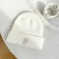 Close-up of white knitted beanie with embroidered P letter and textured pattern - 55-59cm (Elastic) / White