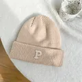 Detail showing the thick knit texture and embroidered P letter on the beige beanie - 55-59cm (Elastic) / Beige