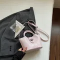 Petit sac seau rose clair au design minimaliste avec poignée et bandoulière réglable - Rose (Sans Charme)