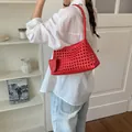 Vue détaillée du sac fourre-tout rouge tissé à la main dans un décor minimaliste chic - Rouge Sisi