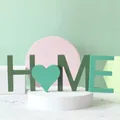 Gros plan sur les lettres HOME en bois avec un cœur pour une décoration de table minimaliste - Maison
