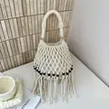 Elegant handcrafted beige woven macrame bucket bag featuring wooden beads and long fringe - Off White