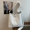 White canvas shoulder tote bag featuring shiny silver star patterns for a minimalist look - White