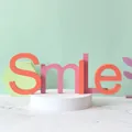 Lettres Smile en bois pastel sur un socle pour la décoration de chambres d'enfants - Sourire