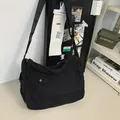 High capacity minimalist black canvas messenger bag featuring a classic flap front pocket - Black