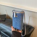 Mini blue denim cylinder crossbody phone bag with silver chain and camellia flower charm. - Denim Style / Dark Blue