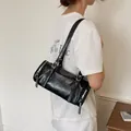 Vintage black minimalist pillow bag shown on model as a stylish underarm shoulder bag - Black