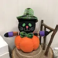 Plush black cat sitting on orange pumpkin Halloween doll decoration for party. - Black Cat Style