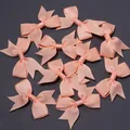 Macro detail of multiple peach grosgrain ribbon bows with fishtail ends for DIY crafts - Size approx 4.5X6cm, ribbon width 1.5cm / Snow Bud
