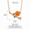 Vintage gold necklace featuring an orange enamel flower and pink crystal pendant - October