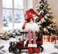 Festive Christmas gnome doll with long legs sitting on a vintage red car model toy - Long Leg with LED / Red