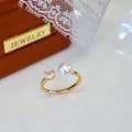 Detailed close-up of adjustable gold ring with freshwater pearl and sparkling stone - Adjustable Open / Gold Base with Large Rhinestone Style / White