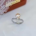 Nahaufnahme eines eleganten Süßwasserperlenrings mit funkelndem Zirkonia-Silberband - Einstellbar Offen / V-Form Zirkonia / Orangerosa