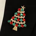Détail d'une broche sapin de Noël dorée avec strass rouges et verts sur tissu noir - Sapin de Noël avec Strass Rouges et Verts (WG-0742)