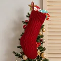 Red knitted Christmas stocking with classic cable stitch pattern hanging on tree - Red Knitted Sock