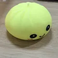 Yellow silicone squishy stress toy shaped like a bun with cute smiley face detail - Smiley Face / OPP Bag / Yellow