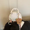 Elegant white faux leather bowling bag featuring a plush bear charm and silver studs - With Charm / White