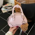 Stylish small pink bowling style handbag featuring a plush bear keychain and rivet details - With Charm / Pink