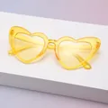 Detailaufnahme einer gelben herzförmigen Sonnenbrille mit glitzerndem Kristallgestell - Glitzerndes Gelb