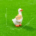 Miniature white duck figurine holding Welcome sign on green grass, size 3.4x2.3x2.2cm. - White Goose Holding Sign