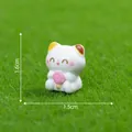 Figurine de chat calicot miniature avec sucette rose sur fond d'herbe verte - Tenant une Sucette (5#)