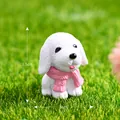 Miniature resin white puppy figurine with pink scarf on grass backdrop - White