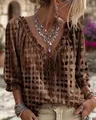 Primer plano de blusa bohemia de lunares con cuello de volantes y lazo frontal - Café