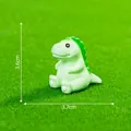 Simpatica miniatura di dinosauro verde su sfondo di erba muschiata, larga 3,7 cm - T-Rex (C0139) / 3.7x3.6cm / T-Rex Verde