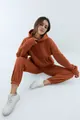 Volledig zicht van een model in een dikke terracotta hoodie en joggingbroek set voor damesmode - Roestvrij Rood