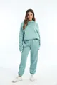 Volledige lichaamsopname van een vrouw in een dikke turquoise hoodie en joggingbroek set - Lichtgroen