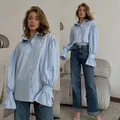 Elegant light blue oversized women's button-down shirt featuring stylish lantern sleeves - S / Tops / Blue