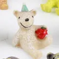 Cute miniature resin bear figurine wearing a green party hat and holding a red strawberry - Bear with Apple