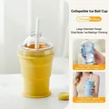 Detail view of yellow collapsible silicone ice ball cup with straw and clear lid - Yellow