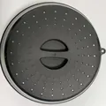 Durable black silicone microwave splash guard cover with steam vents and central handle - Black