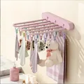 Pink foldable wall-mounted drying rack for socks and underwear shown in bathroom setting - Pink