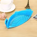 Blue silicone clip-on pot strainer for draining pasta and vegetables in the kitchen. - Blue