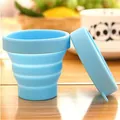 Light blue collapsible silicone travel cup with a matching lid placed on a wooden table - 101-200ml / Blue