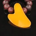 Professional heart-shaped orange resin Gua Sha board for facial massage and wellness - V-Shaped Board