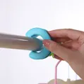 Blue silicone windproof fastener ring being clipped onto a clothes rail. - Blue