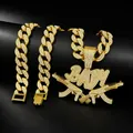Vue détaillée du pendentif BABY doré avec fusils AK-47 croisés sur chaîne Cubaine. - Pendentif Avec Chaîne Cubaine 18 Pouces / Or