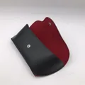 Detail of black leather glasses case with soft red suede lining and snap closure - Red Lining Button Glasses Case