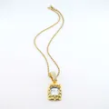 Close-up of golden rope chain necklace with a large clear rectangular gemstone pendant - Rope Chain Necklace / 20 inch / Gold White